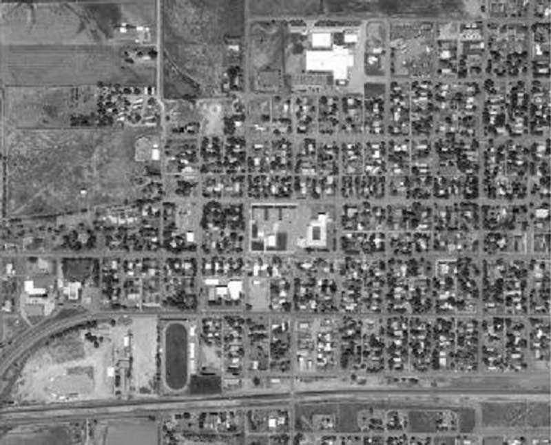 Grayscale aerial view of roads and houses. 