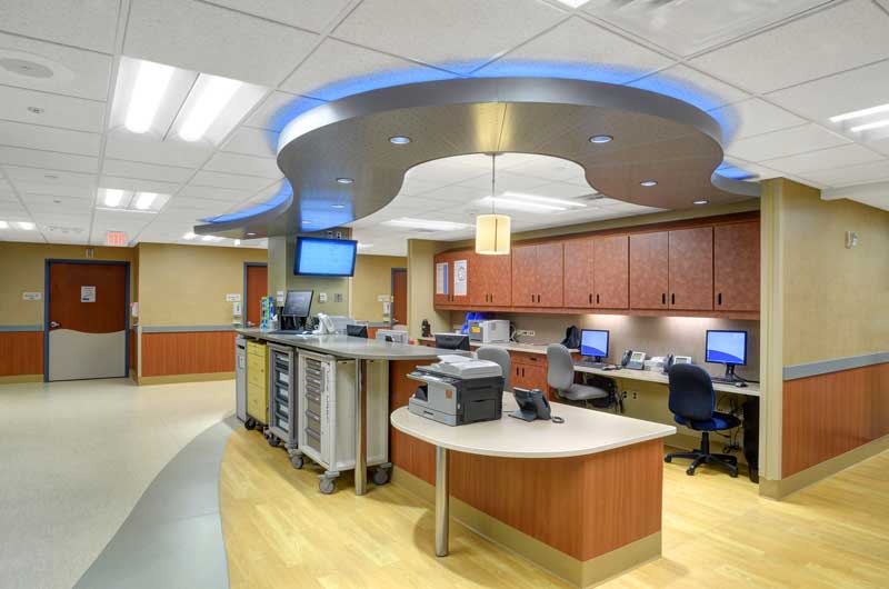 Interior view of the Penrose Emergency Department remodel, showcasing a clean and modern hallway with bright lighting, neutral tones, and clear signage for navigation. The design emphasizes functionality and a calming atmosphere for patients and staff.