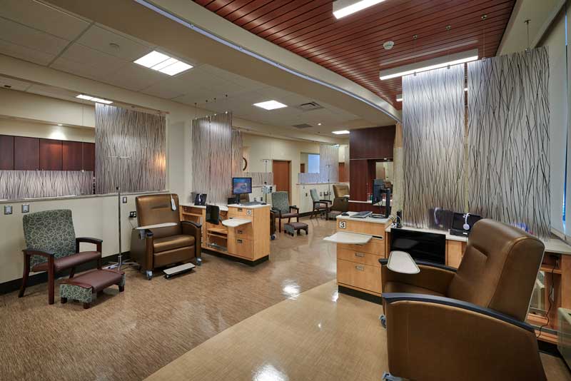 Interior view of the SLVH Oncology Infusion Center, featuring a calm and modern design with comfortable infusion chairs, large windows allowing natural light, and a soothing color palette to create a healing environment for patients.