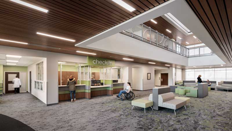 Interior view of the PCHC first-floor waiting area, featuring a modern and welcoming design with comfortable seating, warm lighting, and large windows allowing natural light. The space is designed to create a calming and patient-friendly atmosphere.