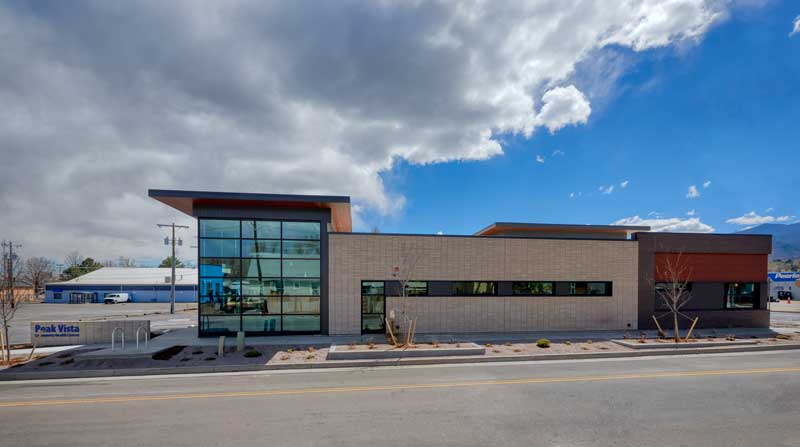 Exterior view of the Peak Vista medical office building, showcasing a contemporary design with large windows, a combination of brick and metal materials, and a well-landscaped entrance. The building emphasizes accessibility and a welcoming atmosphere for patients and visitors.