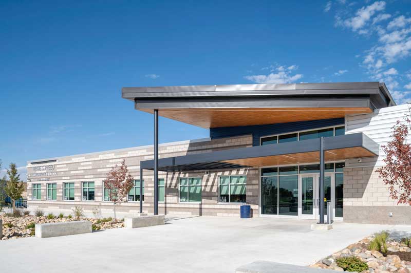 Exterior view of Nettie S. Freed Expeditionary School, showcasing a contemporary design with a mix of brick and metal materials, large windows, and a welcoming entrance. The modern architecture emphasizes accessibility and a dynamic learning environment.