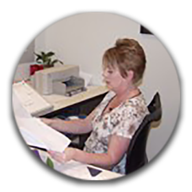 Michelle Kersey sitting at her desk and reviewing papers