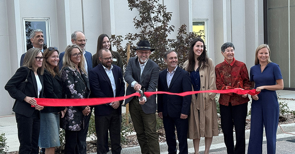 a group of people prepare to cut a ribbon at step springs